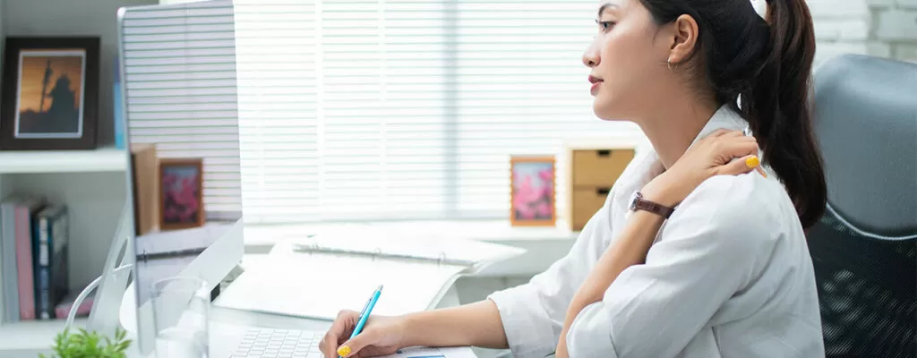 a young sitting in the office suffering from back pain