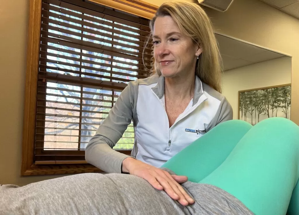 Female therapist assisting pregnant patient with therapy as part of pelvic health therapy.